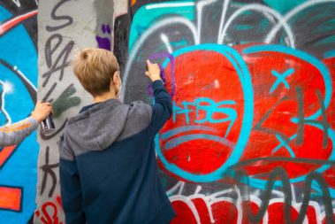 zwei Menschen sprühen Graffiti